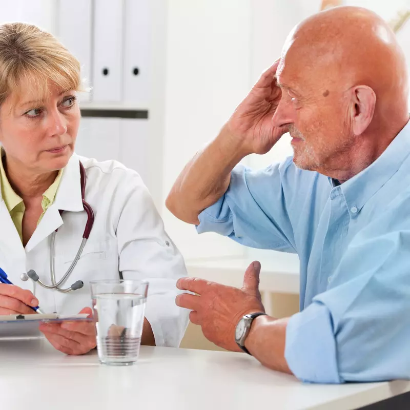A man discusses his symptoms with his doctor.