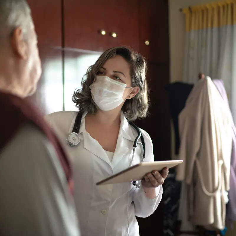 A female doctor talking to her senior patient