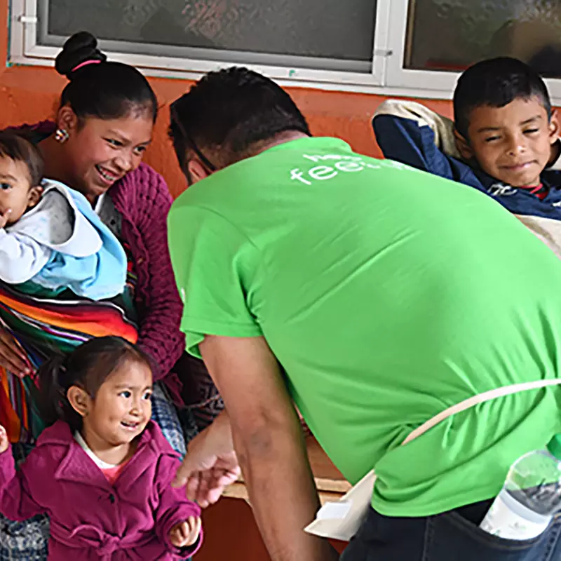 An AdventHealth team member greets a Guatemala family outside a malnutrition center in San Juan, Guatemala.