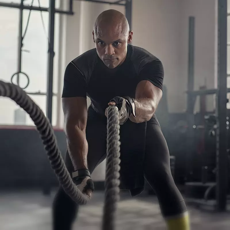 A man exercising with battle ropes.