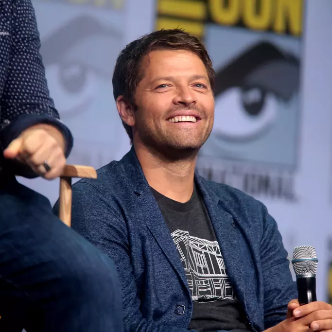 Actor Misha Collins sits onstage at Comic Con with his cast members