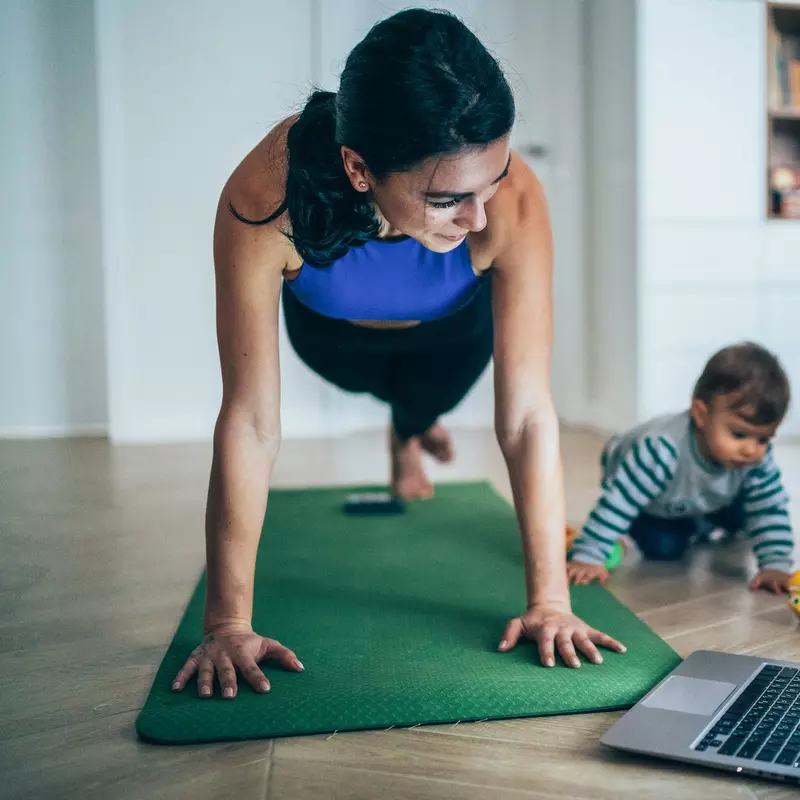 A mom exercising at home with her baby. 