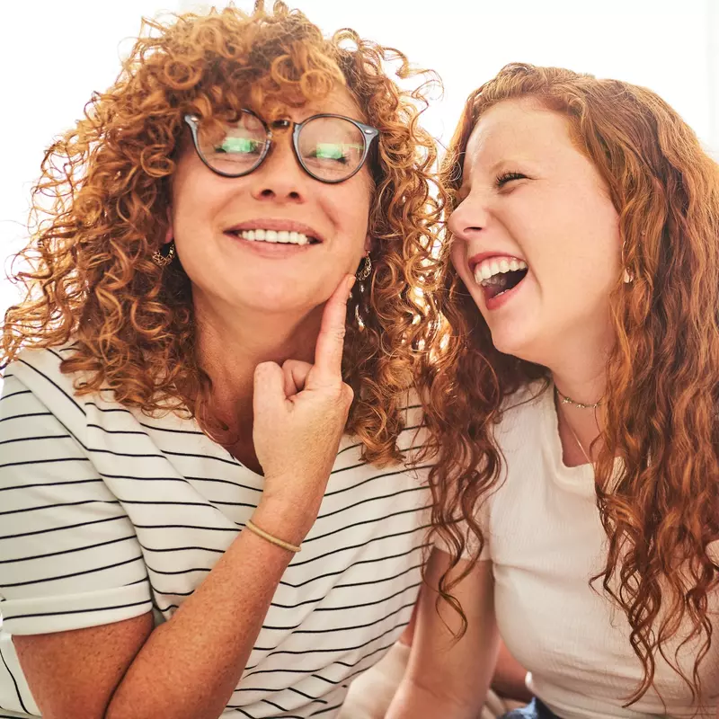 A mother and daughter joking and laughing together. 