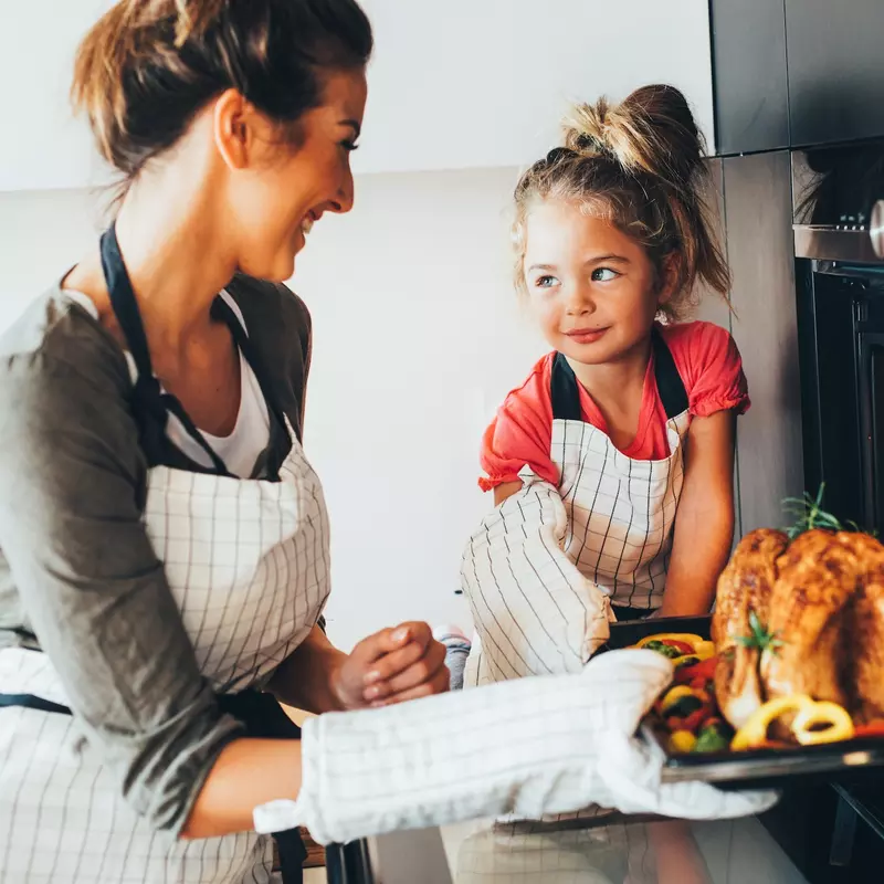 A mom prepares a healthy turkey recipe for Thanksgiving with her daughter.