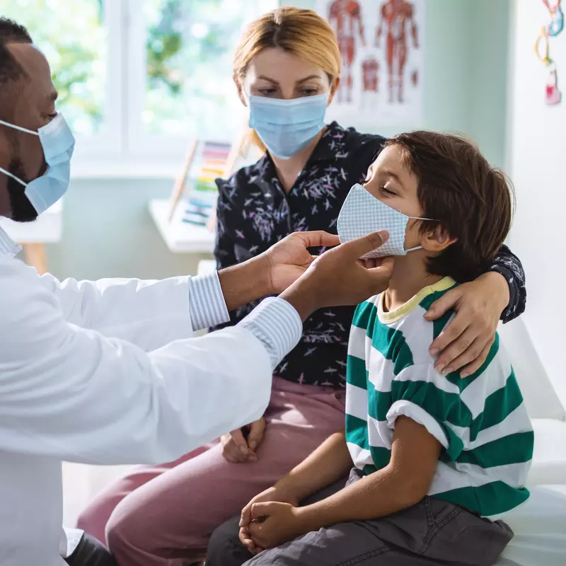 A doctor examines a boy during an appointment.