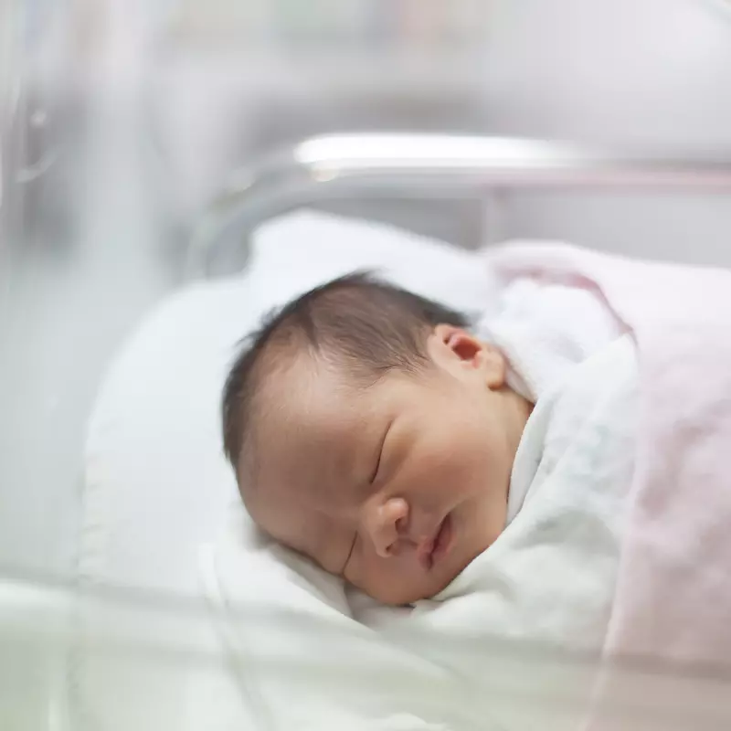 A newborn rests in her bed in the delivery room