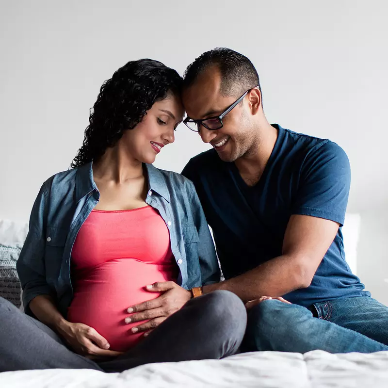 A pregnant couple at home.