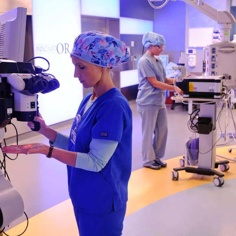 Medical specialists work with robotic surgery equipment.
