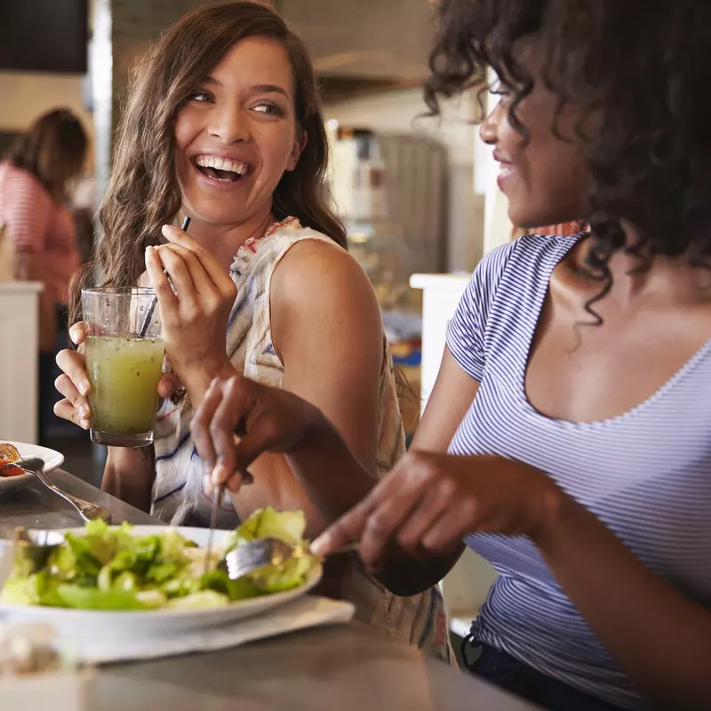 Two women eat a healthy lunch together.