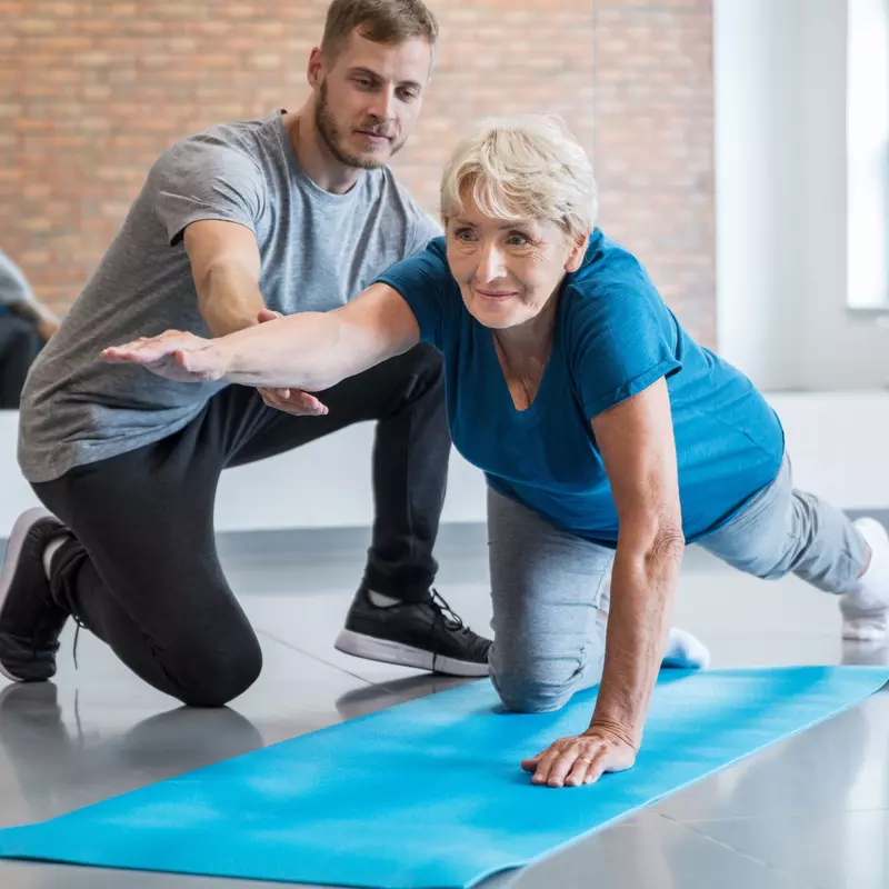 A woman does strengthening exercises with her physical therapist.