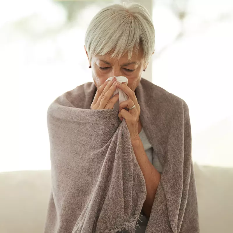 a woman blows her nose