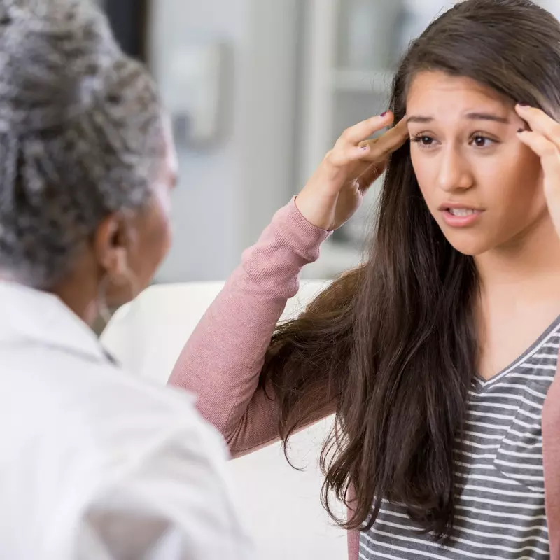 A woman discusses her symptoms with her doctor.