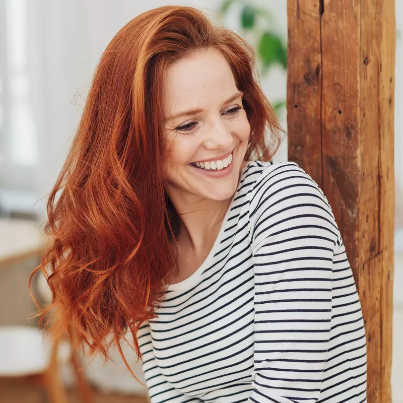 Woman with red hair smiling.