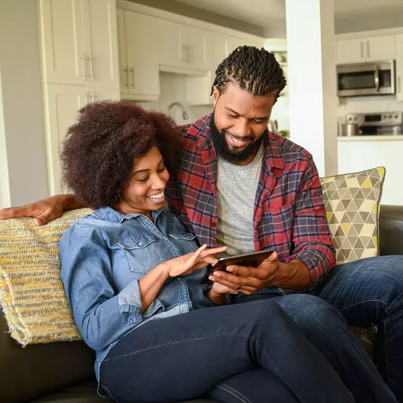 Black Couple Looking at Report on Tablet