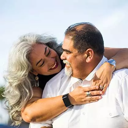 Hispanic couple embracing and smiling at each other