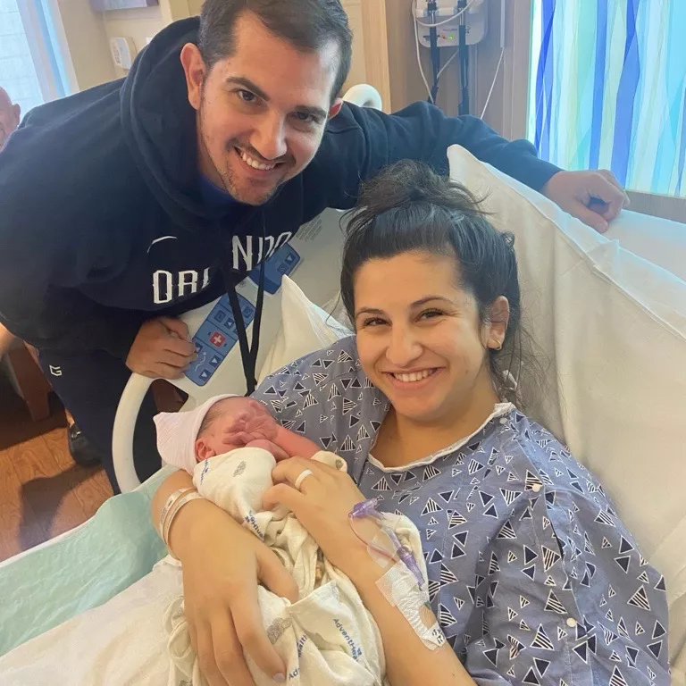 Photo of mom in the hospital holding her baby next to the dad