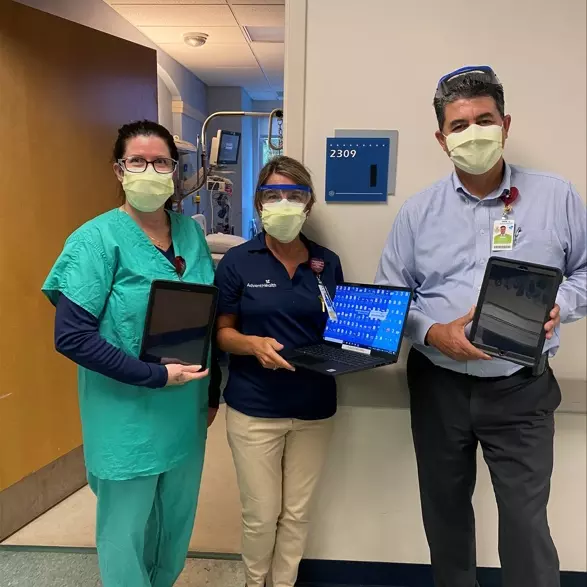 AdventHealth Palm Coast team members Jennifer Mellow, Wendi Coheley and Eddie Conclaves with the tablets used to host a patient's virtual anointing ceremony.