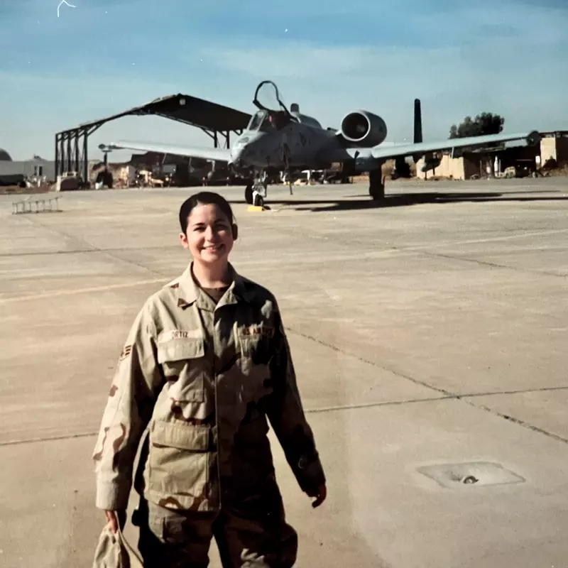 A photo of Jennifer Vincent in front of a military aircraft during her time in the service.