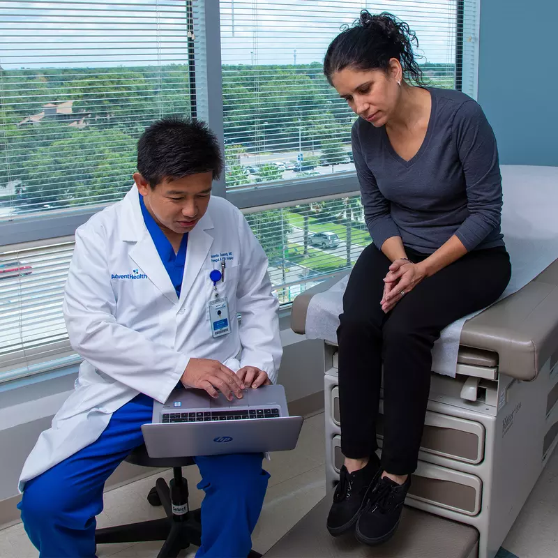 Dr. Iswanto Sucandy showing patient a something on a laptop.