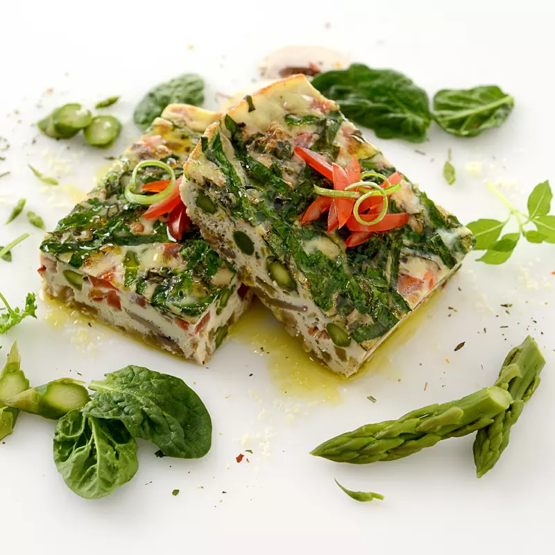 two square slices of a veggie-packed egg frittata