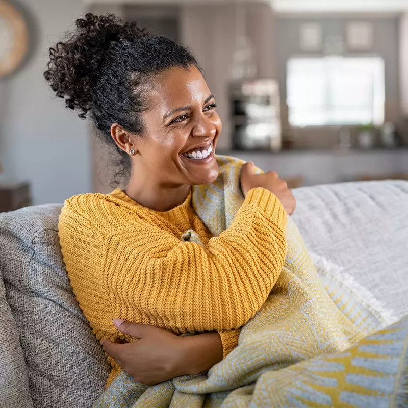 A woman smiling on her couch