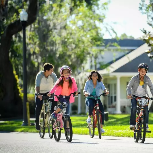 A family rides their bikes in neighborhood
