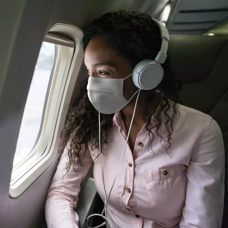 A woman traveling wearing a mask.