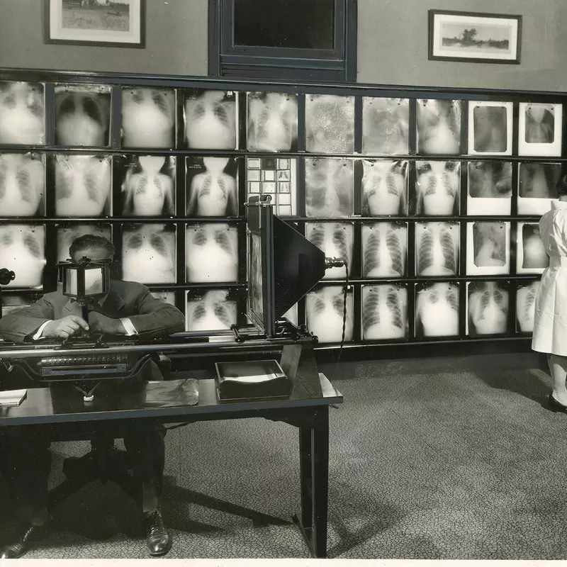 Antique photo of a doctor and nurse looking at x-rays.