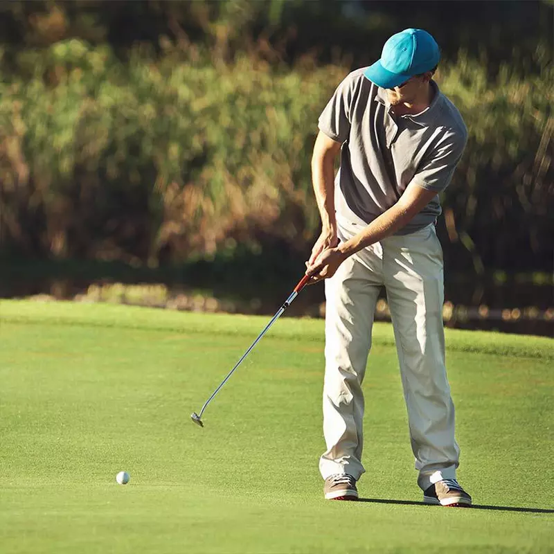 man in blue hat playing golf