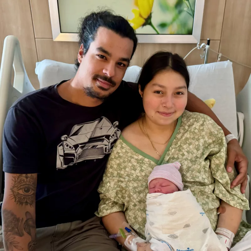 Parents hold their new baby who was born during Hurricane Milton.