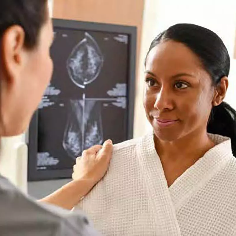 Clinician talking to a woman about her mammography.