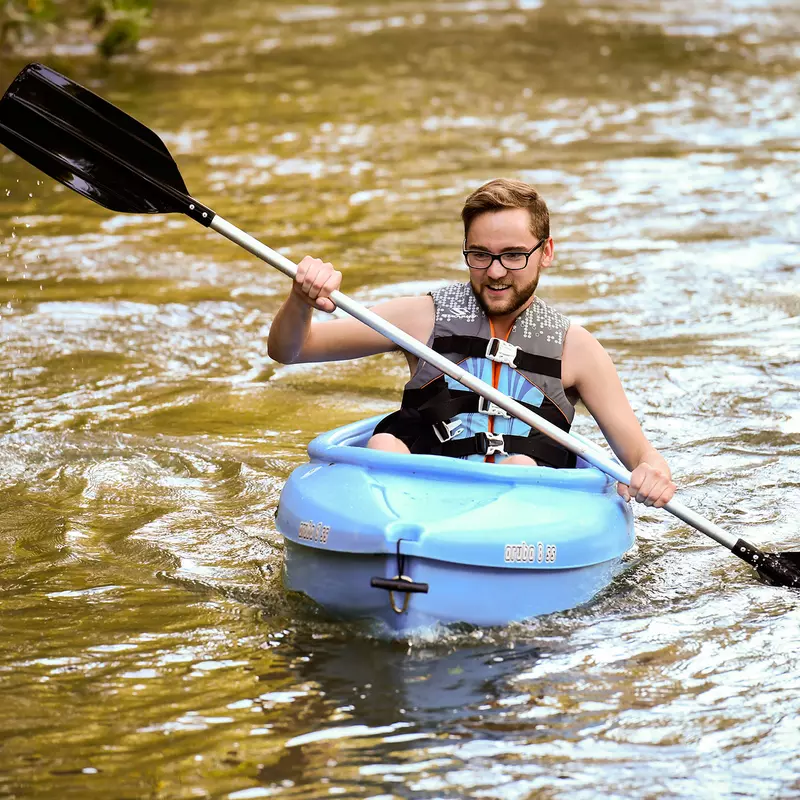 A young man kayaking in the river.