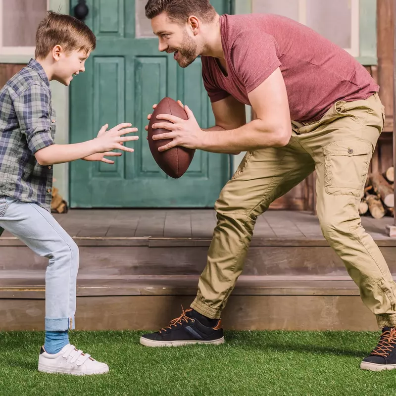 Father and son playing a backyard game of football.
