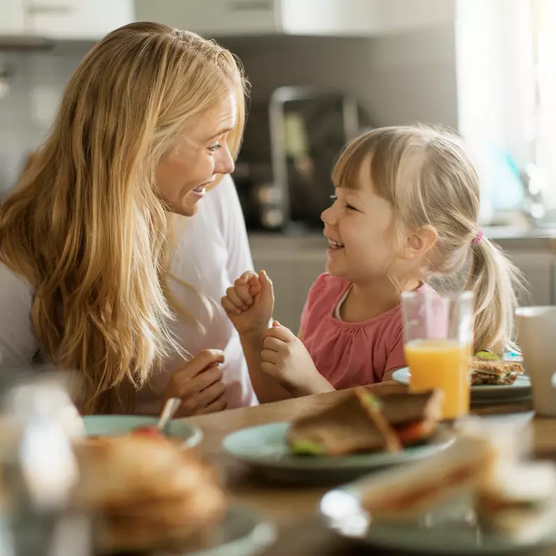 A mother and daughter eating breakfast together.