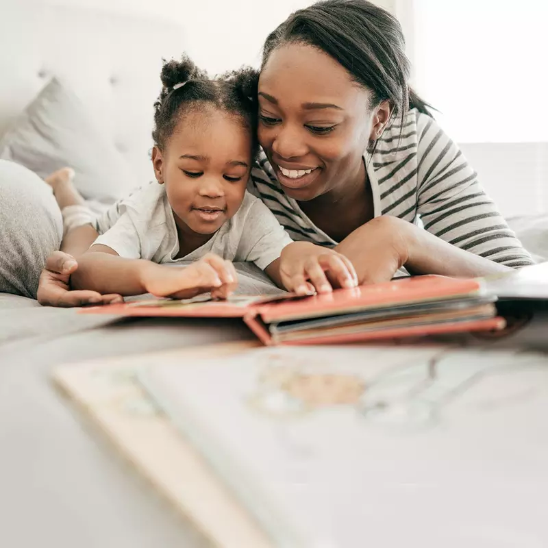 A mother reading to her daughter. 