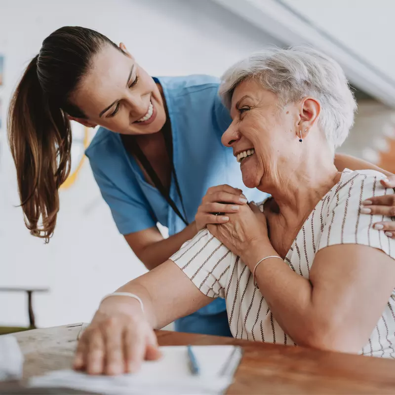 Nurse smiling with senior woman patient.