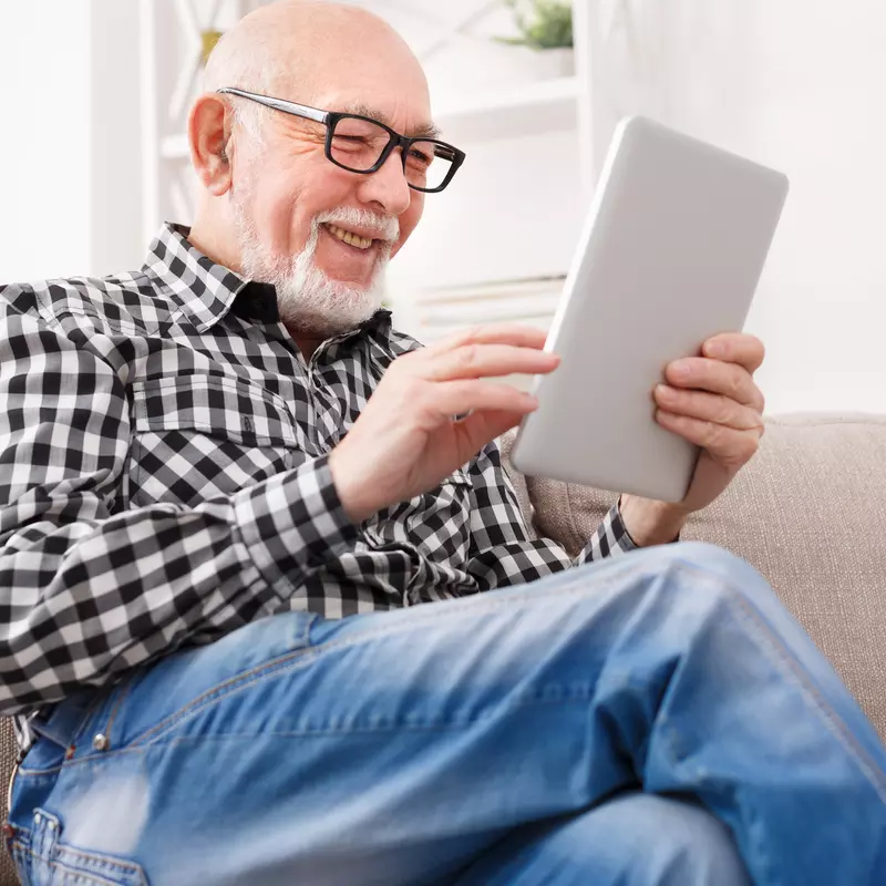 Older man reading on electronic device