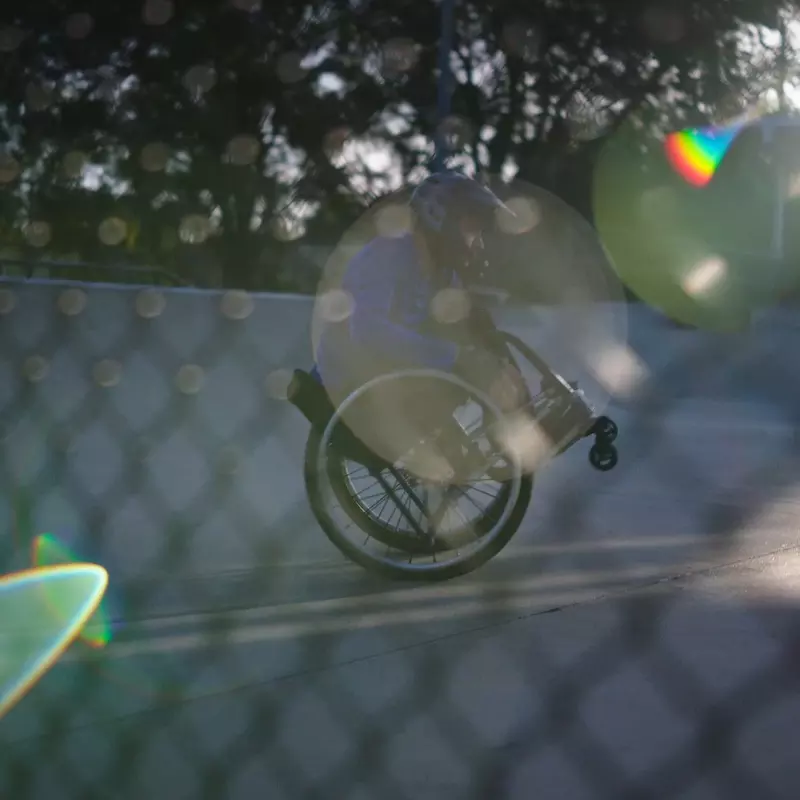 Man in a wheelchair doing a wheelie