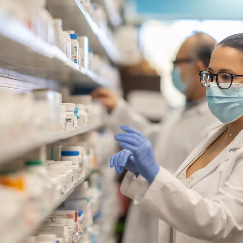 Female Pharmacist getting medication from shelf