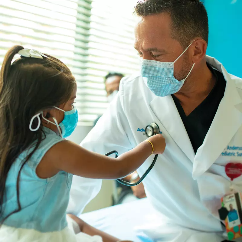 Physician playing with little girl patient