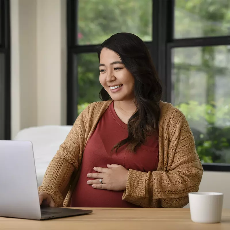 Happy pregnant woman using a computer