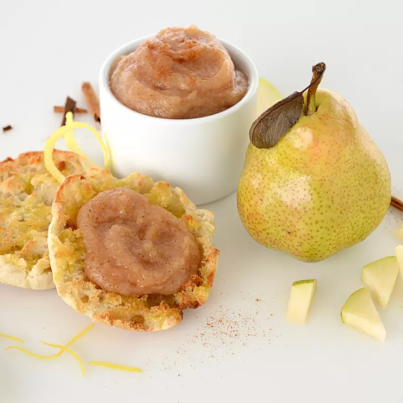 dish and muffin with pear and date sauce next to a whole pear and pear pieces