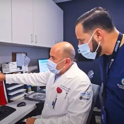 Dr. Michael Hawks (seated), orthopedic trauma surgeon and medical director for AdventHealth and Rothman Orthopaedics in Central Florida, confers with a fellow physician.