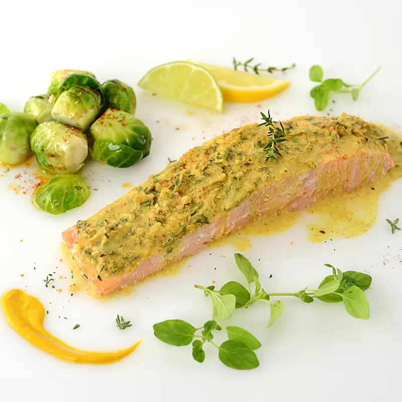 Herb-crusted salmon filet with Brussels sprouts and herb garnish