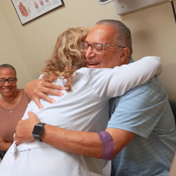 Doctor hugging heart transplant patient.