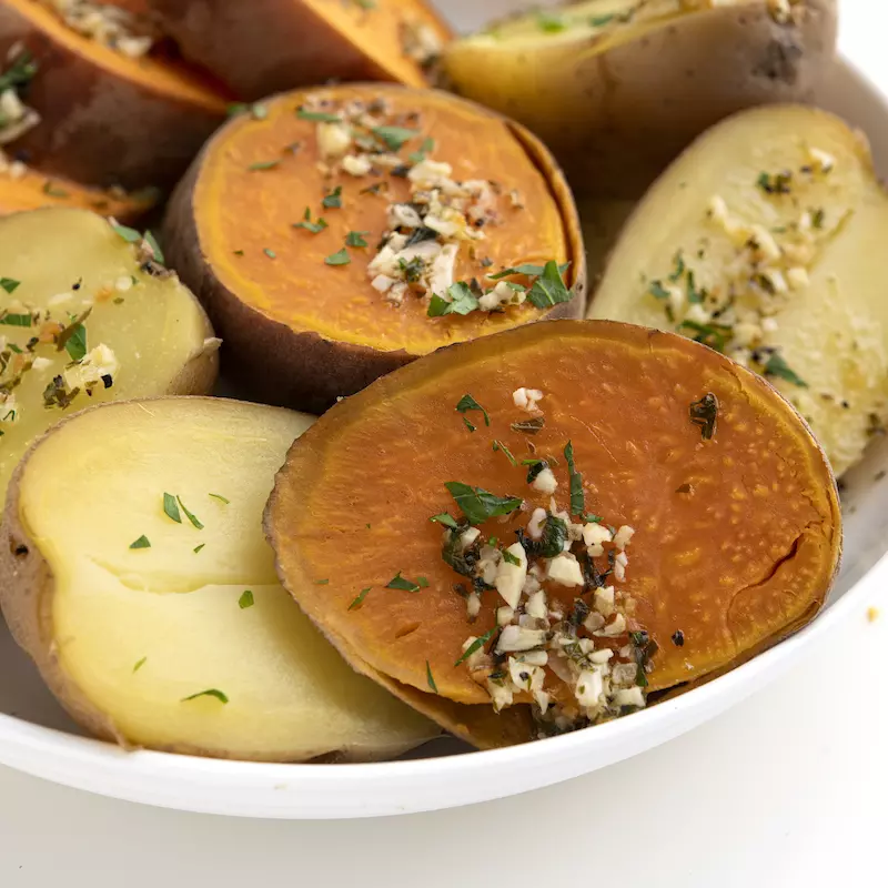 White bowl filled with cooked russet and sweet potatoes
