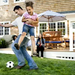 man playing soccer with daughter