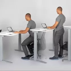 Standing and sitting at desks.