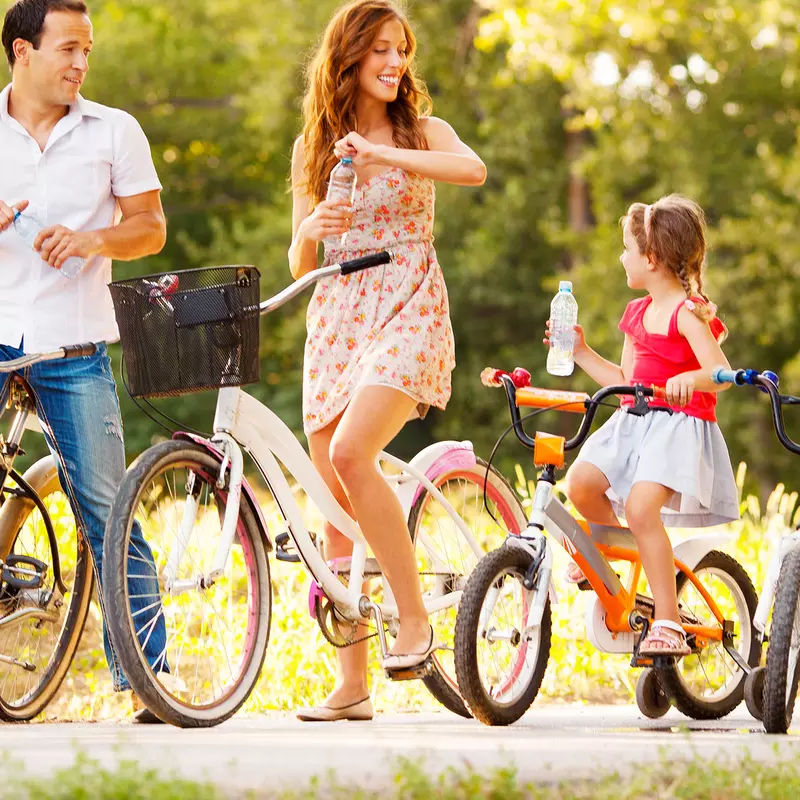 A family takes time to hydrate during a summer bike ride.