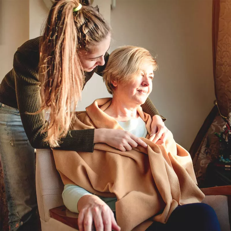 Younger woman taking care of female hospice patient